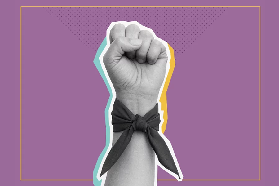 Puño levantado con pañuelo en la muñeca sobre fondo morado.